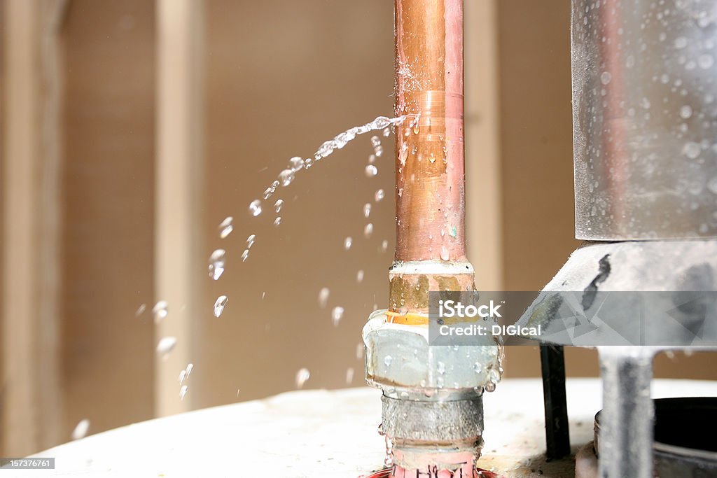 Water leaking out of a pipe on top of a water heater.